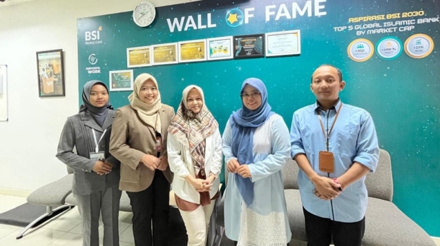 Mahasiswa FEBI UIN Raden Mas Said Surakarta berdiri rapi bersama tim BSI KCP Karanganyar Palur 1 usai sesi monitoring, mengenakan kemeja formal dengan latar branding bank dan suasana ruang kerja profesional.