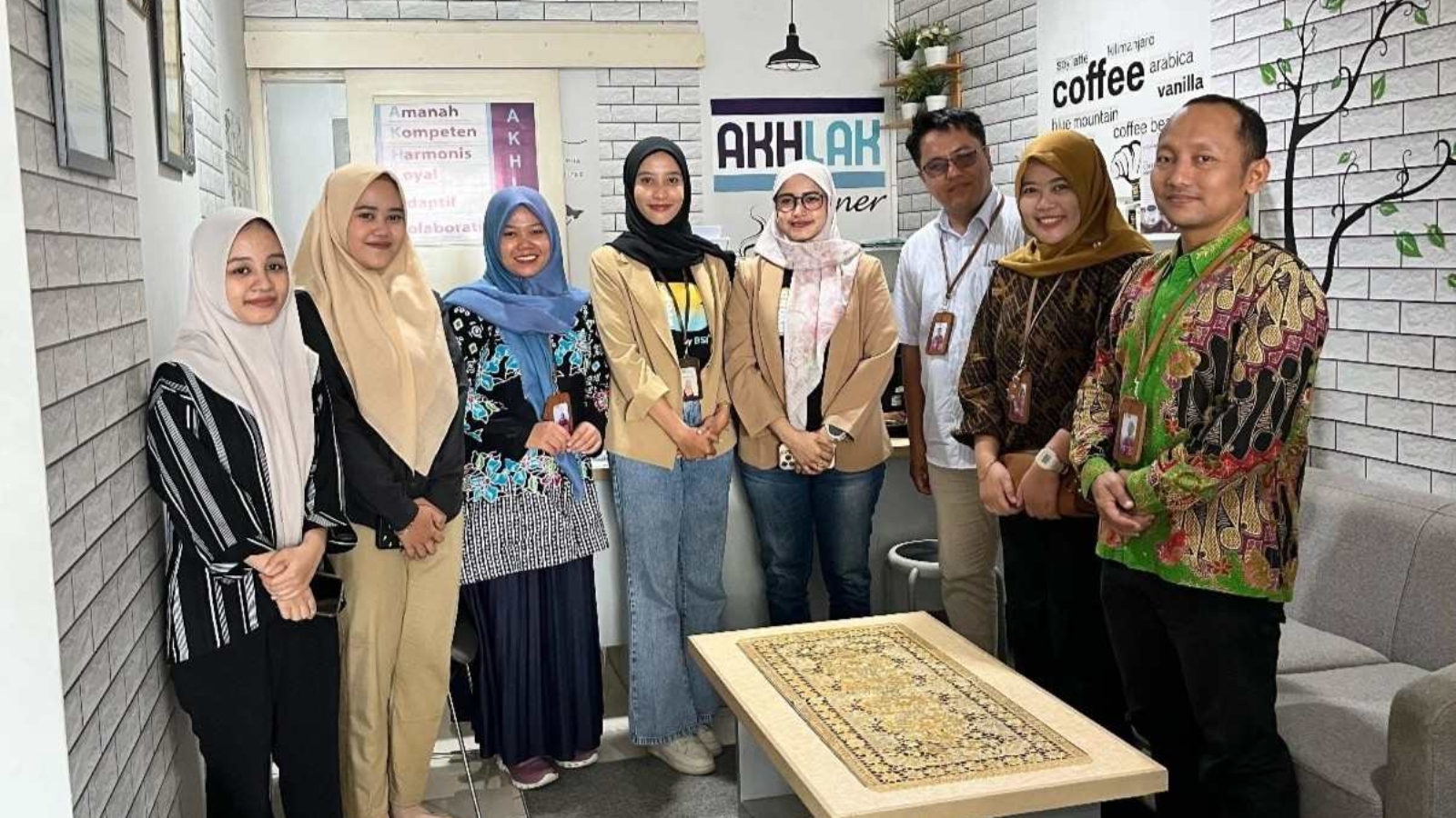 Mahasiswa FEBI UIN Raden Mas Said Surakarta berdiri rapi bersama tim BSI Wonogiri usai sesi monitoring, mengenakan kemeja formal dengan latar branding bank dan suasana ruang kerja profesional.
